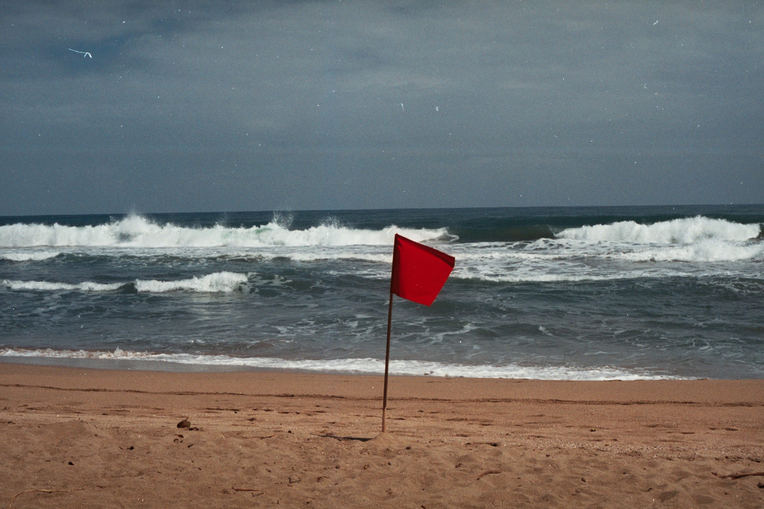Red flag planted on a beach